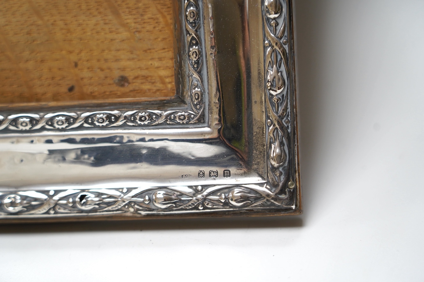 A George VI Art Deco silver mounted inkwell, Sheffield, 1949, 15.1cm and two early 20th century silver mounted rectangular photograph frames, largest 34.2cm. Condition - poor to fair